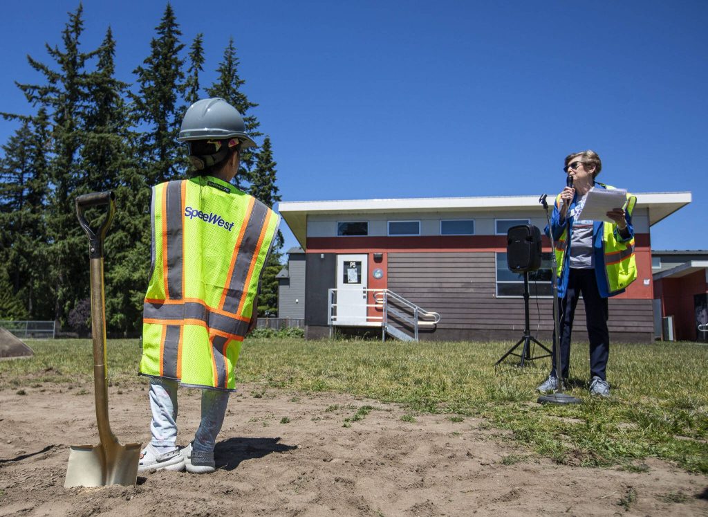 Dylan Garduque, 6, listens to Edmonds School Board President Nancy Katims speaks at the Oak Heights Elementary groundbreaking on Tuesday, June 25, 2024, in Lynnwood, Washington. (Olivia Vanni / The Herald)
