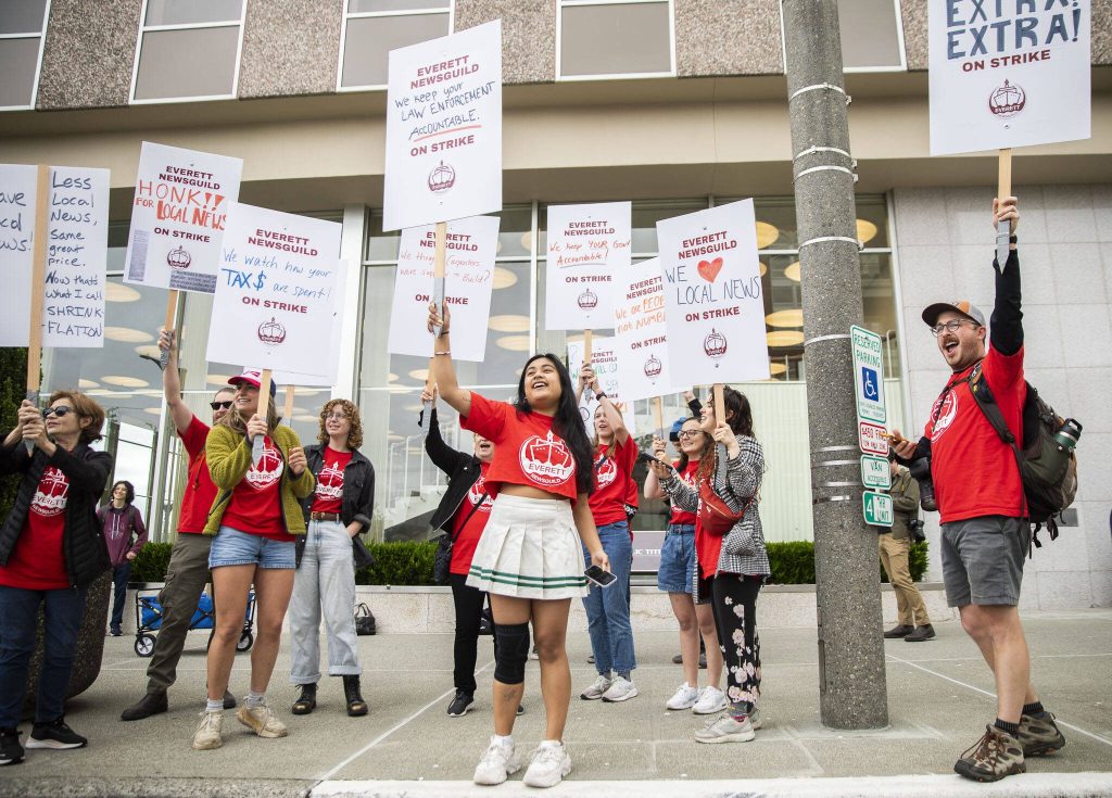 Everett NewsGuild members cheer as a passing car honks in support of their strike on Monday, June 24, 2024, in Everett, Washington. (Olivia Vanni / The Herald)