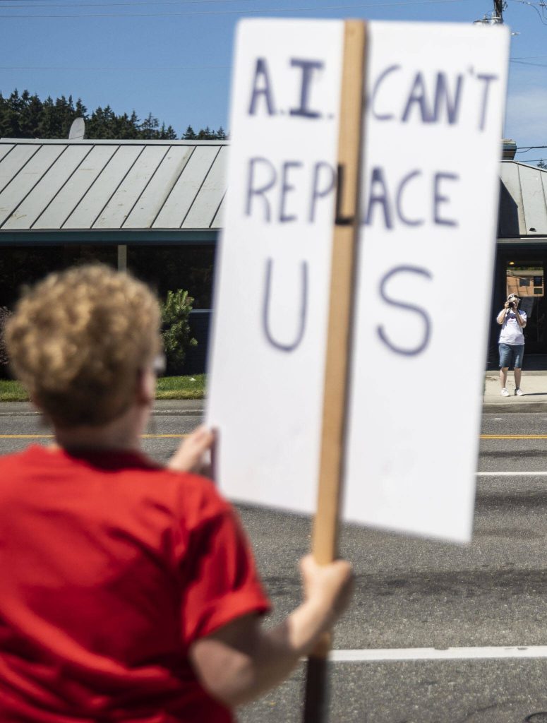 A person stops to take photos of the Everett NewsGuild during the second day of their strike on Tuesday, June 25, 2024 in Everett, Washington. (Olivia Vanni / The Herald)