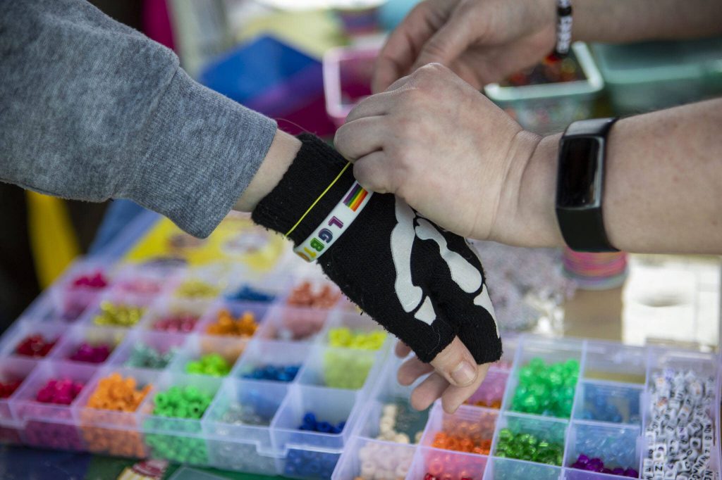 People participate in making bracelets during the third annual Arlington Pride event in Arlington, Washington on Sunday, June 2, 2024. (Annie Barker / The Herald)