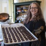Mona Newbauer poses for a photo with caramels inside her store Sweet Monas Chocolates on March 21, 2024 in Langley. (Annie Barker / The Herald)