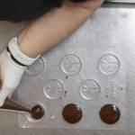 Mona Newbauer fills peace sign molds with chocolate inside her store Sweet Monas Chocolates on March 21, 2024 in Langley. (Annie Barker / The Herald)