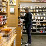 Becky Thomas packages raw honey in the bulk foods section Tuesday morning at Central Market in Mill Creek on April 9, 2019. (Kevin Clark / The Herald)