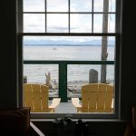 A boat passes by outside the window of Ferry Cove on May 29, 2024, in Clinton. (Ryan Berry / The Herald)