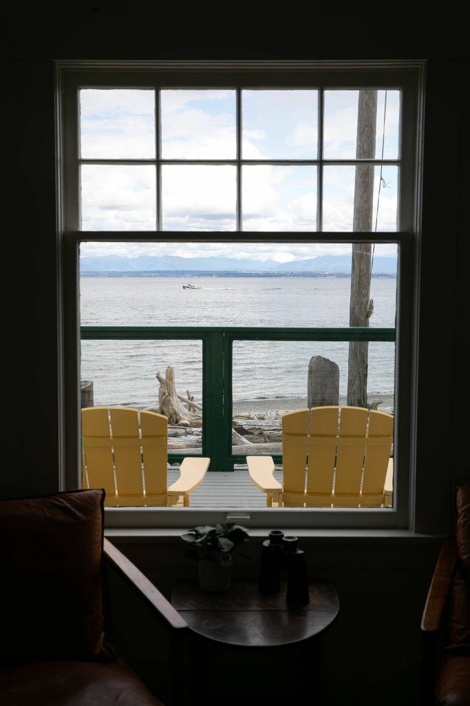 A boat passes by outside the window of Ferry Cove on May 29, 2024, in Clinton. (Ryan Berry / The Herald)