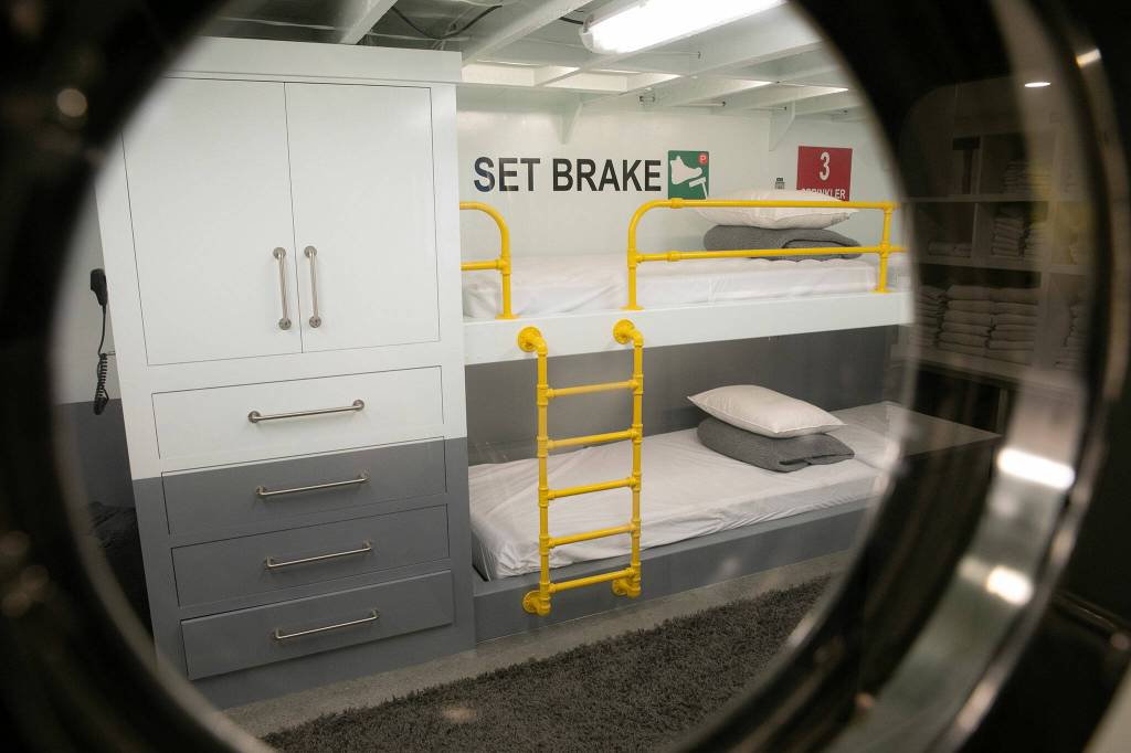 The basement bunkbeds at Ferry Cove can be seen through a porthole on May 29, 2024, in Clinton. (Ryan Berry / The Herald)