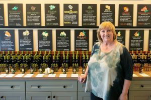 A Bit of Taste owner Debe Franz stands in front of a long list of olive oils and balsamic vinegars inside her storefront on Wednesday, June 12, 2024, in Snohomish, Washington. (Ryan Berry / The Herald)