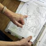 Kim Skarda points at her home on a map on Thursday, June 20, 2024 in Concrete, Washington. A community called Sauk River Estates has a very steep slope above it. There is a DNR-approved timber sale that borders the estate properties, yet they were not consulted about the sale before approval. The community has already appealed the sale and has hired their own geologist to conduct a slope stability report at the site. (Annie Barker / The Herald)