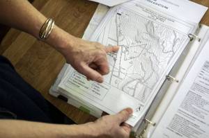 Kim Skarda points at her home on a map on Thursday, June 20, 2024 in Concrete, Washington. A community called Sauk River Estates has a very steep slope above it. There is a DNR-approved timber sale that boarders the estate properties, yet they were not consulted about the sale before approval. The community has already appealed the sale and has hired their own geologist to conduct a slope stability report at the site. (Annie Barker / The Herald)