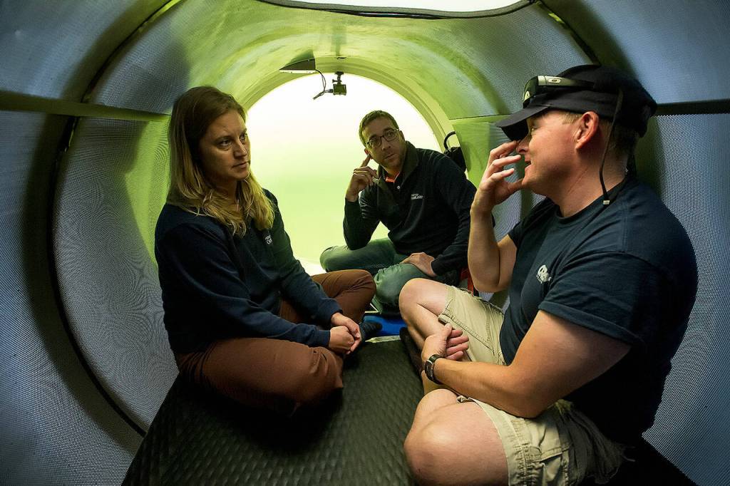 -David Lochridge, right, describes diving at great depths to Bonnie Carl and Josh Dean as they sit in the OceanGate sub Cyclops1 submerged in the waters of the Port of Everett Marina on Thursday, May 18, 2017 in Everett, Wa. OceanGate plans to carry paying customers on dives to the RMS Titanic in 2018. (Andy Bronson / The Herald)