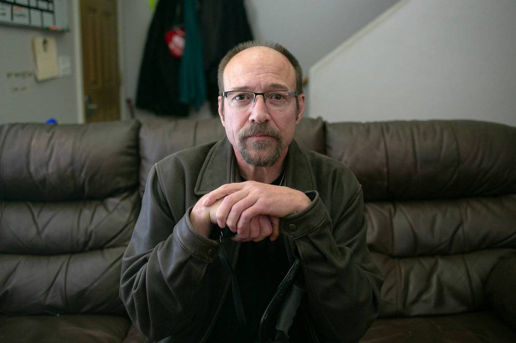 John Jacobs, 58, sits inside at a Hand Up Housing residence on May 31, 2024, in Edmonds, Washington. (Ryan Berry / The Herald)