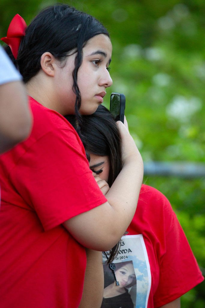 Macy Nearing consoles Kayri Alverez during a vigil held in memory of Jayda Woods-Johnson at Mountlake Terrace High School on Sunday, July 7, 2024, in Mountlake Terrace, Washington. The two were close friends with Jayda and helped lead her vigil. (Ryan Berry / The Herald)