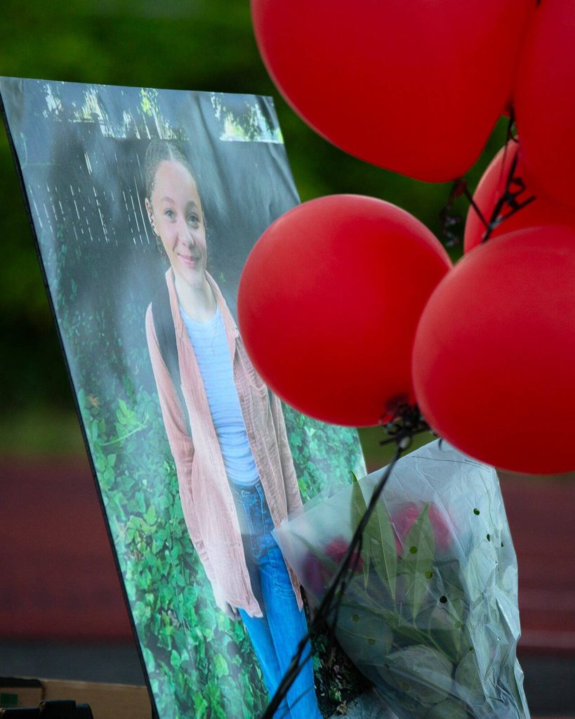Red balloons surround a photo of Jayda Woods-Johnson during a vigil held in her memory at Mountlake Terrace High School on Sunday, July 7, 2024, in Mountlake Terrace, Washington. (Ryan Berry / The Herald)