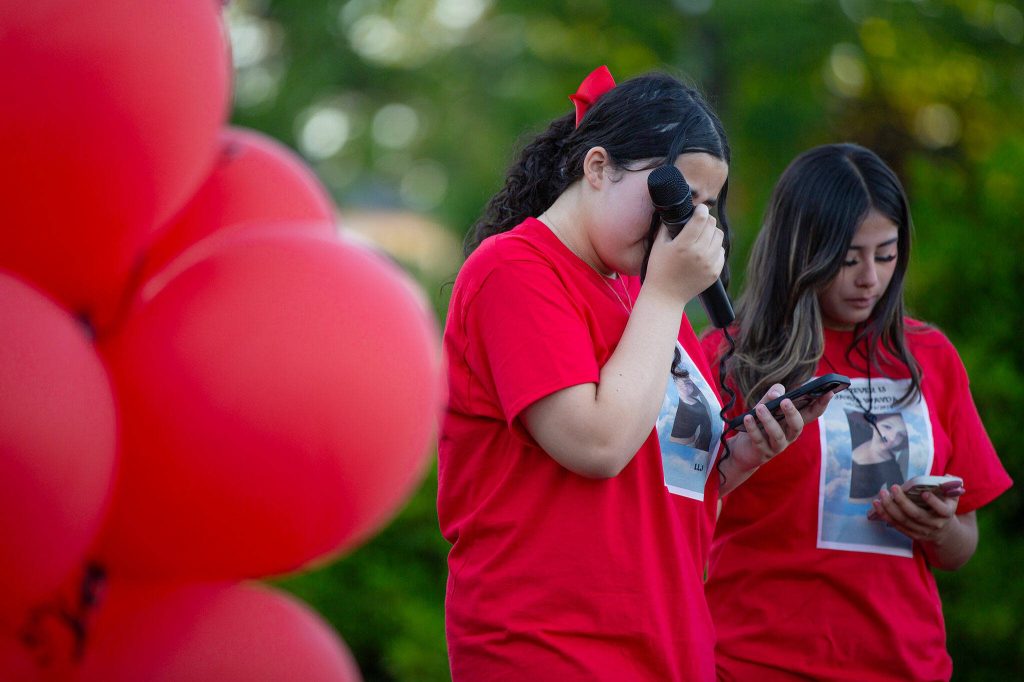 Macy Nearing, alongside Kayri Alverez, wipes away tears while speaking during a vigil held in memory of Jayda Woods-Johnson at Mountlake Terrace High School on Sunday, July 7, 2024, in Mountlake Terrace, Washington. (Ryan Berry / The Herald)