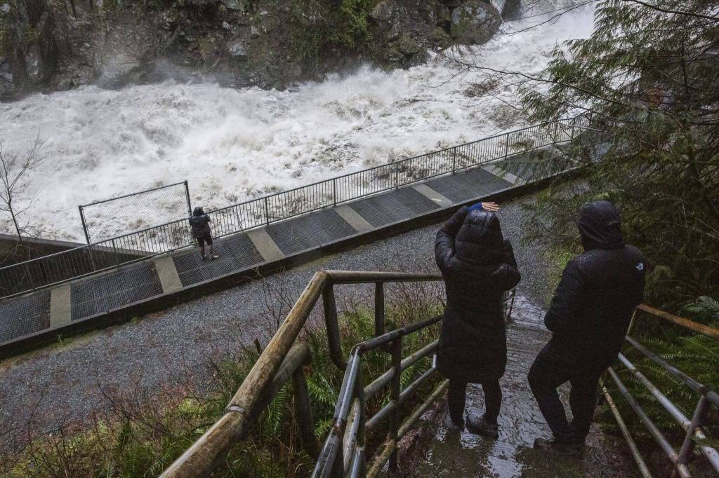 People pause on the stairs to look at the water rushing through the Granite Falls Fish Ladder on Saturday, Feb. 1, 2020 in Granite Falls, Washington. (Olivia Vanni / The Herald)