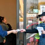Joanne Fisher, right, a meat wrapper with the Marysville Albertsons, hands a leaflet to a shopper during an informational campaign on Wednesday, Nov. 9, 2022. Fisher was one of about a dozen grocery store workers handing out leaflets to shoppers about the proposed merger between Albertsons and Kroger. (Mike Henneke / The Herald)