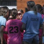 Players and coaches of We Fired The Dads huddle during the Everett 3on3 tournament in downtown Everett, Washington on Sunday, July 14, 2024. (Annie Barker / The Herald)