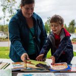 Samantha Grospe helps her son Everett Grospe, 4, pick a book during Lake Stevens Education Foundation Dolly Parton Imagination Library celebration on Sept. 21, 2018 in Lake Stevens, Wa. (Olivia Vanni / The Herald)