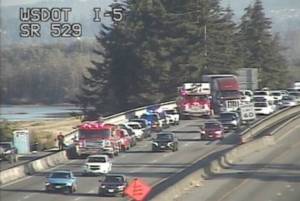 Traffic camera shows Everett and Marysville firefighters on the scene of a crane accident along northbound I-5 near milepost 198 Tuesday evening. (Provided photo)