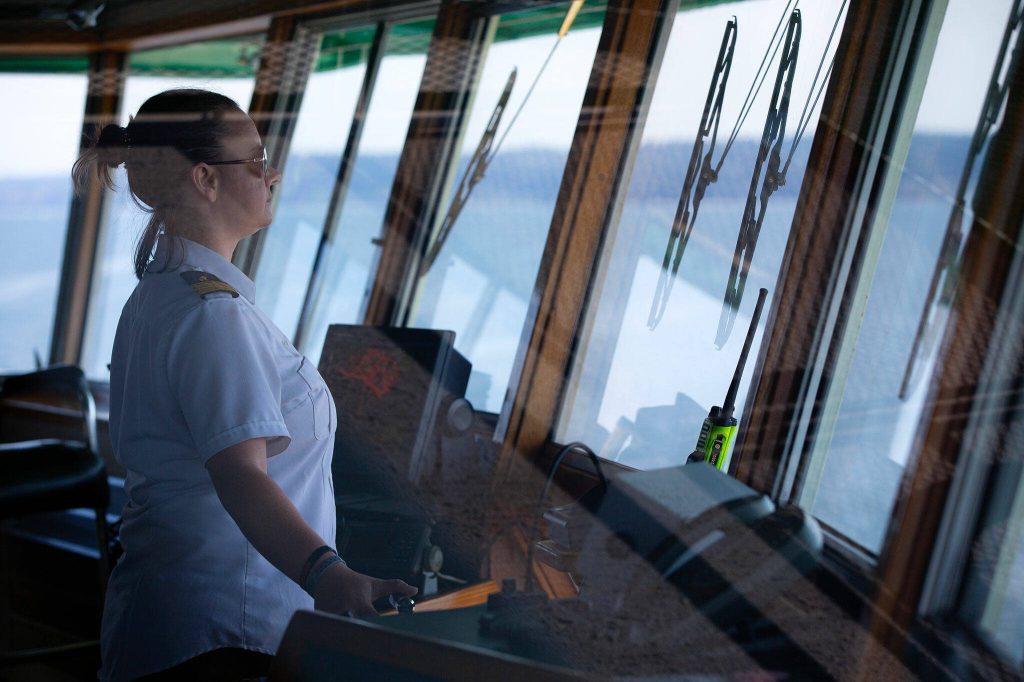 Mate in training Claire OLeary scans for obstacles as she makes the approach to Edmonds aboard the MV Spokane on the Edmonds/Kingston ferry route Thursday, July 18, 2024, near Edmonds, Washington. (Ryan Berry / The Herald)