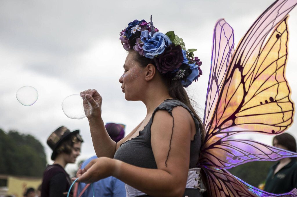 An individual blows bubbles using their hand as a wand during the Washington Midsummer Renaissance Faire at Sky Meadows Park in Snohomish, Washington, on Sunday, Aug. 06, 2023. (Annie Barker / The Herald)