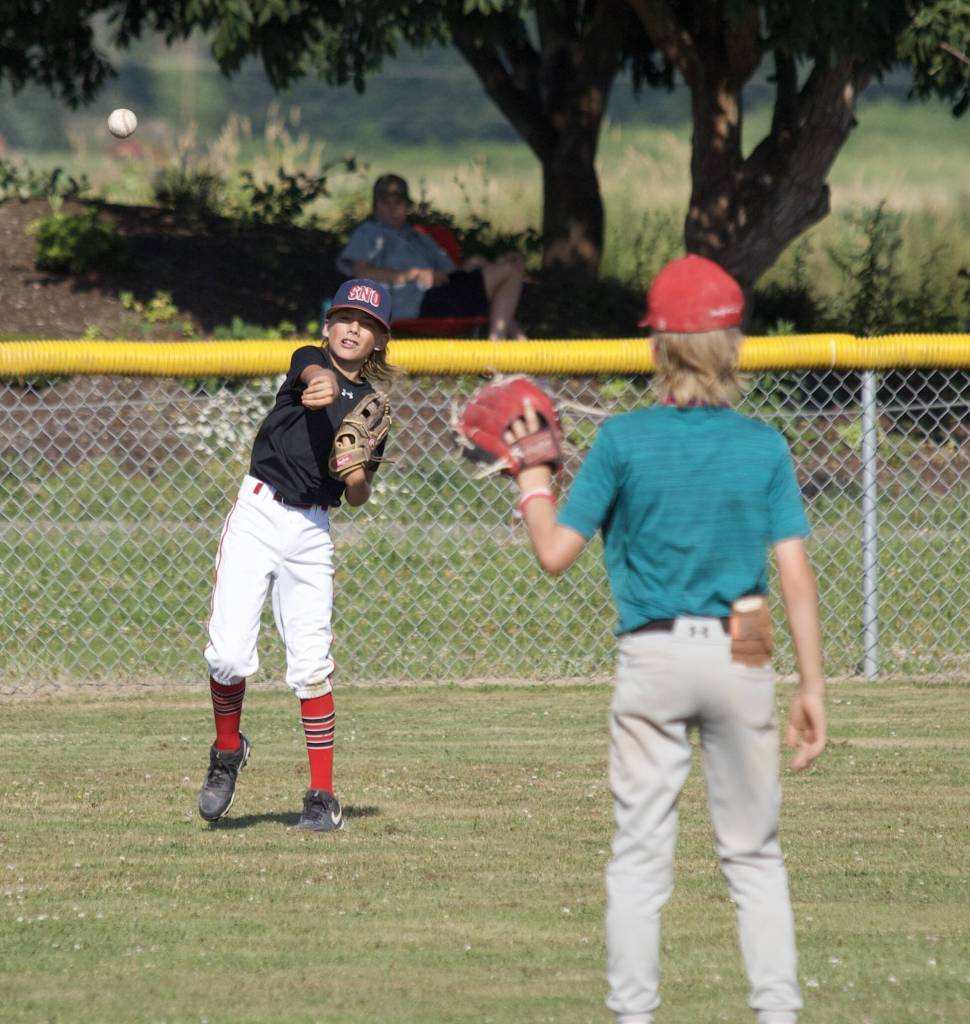 Jameson Tarin throws the ball to Barrett Stedford during practice at the Snohomish Little League Complex in Snohomish, Washington on Thursday, July 18, 2024. (Taras McCurdie / The Herald)