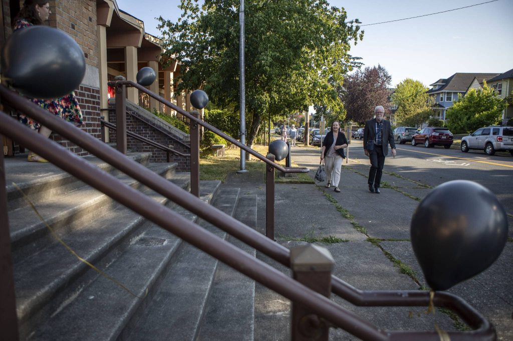 Interfaith Family Shelter Executive Director Jim Dean, right, walks to his retirement party at Trinity Episcopal Church in Everett, Washington, on Thursday, July 25, 2024. (Annie Barker / The Herald)