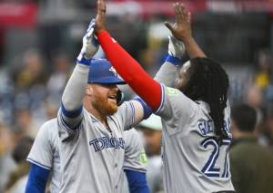 Justin Turner (2) of the Toronto Blue Jays is congratulated by Vladimir Guerrero Jr. (27) after hitting a solo home run on April 19 in San Diego, California. The Seattle Mariners acquired Turner on Monday. (Denis Poroy / Getty Images)