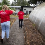 Claire Luvera, left, and Kayla Carter walks down a concrete path that they discovered only after clearing away blackberries on Monday in Marysville. (Olivia Vanni / The Herald)