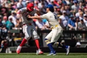 Third baseman Josh Rojas (4) of the Seattle Mariners tags out Bryce Harper (3) of the Philadelphia Phillies in a rundown between third base and home plate during the fourth inning at T-Mobile Park on Sunday in Seattle. (Stephen Brashear / Getty Images)