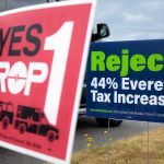 Opposing signs regarding Prop 1 are posted along Colby on Tuesday, July 30, 2024, in Everett, Washington. (Ryan Berry / The Herald)
