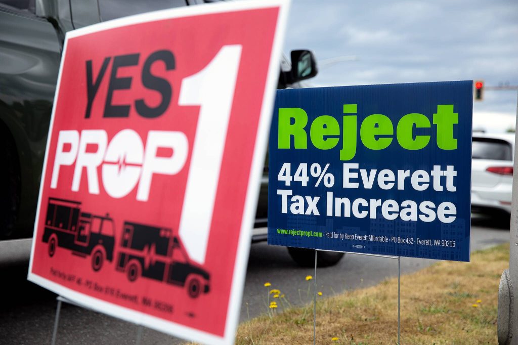 Opposing signs regarding Prop 1 are posted along Colby on Tuesday, July 30, 2024, in Everett, Washington. (Ryan Berry / The Herald)