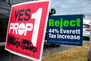 Opposing signs regarding Prop 1 are posted along Colby Avenue on Tuesday, July 30, 2024, in Everett, Washington. (Ryan Berry / The Herald)