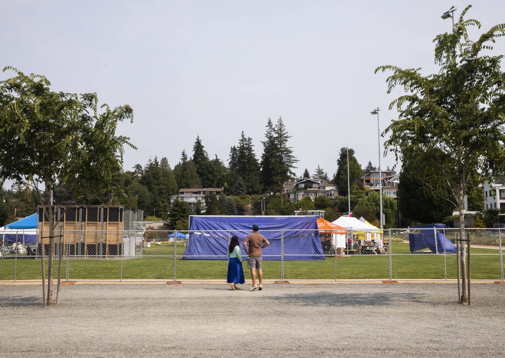People look over the fence before the opening of Taste Edmonds on Friday in Edmonds. (Olivia Vanni / The Herald)