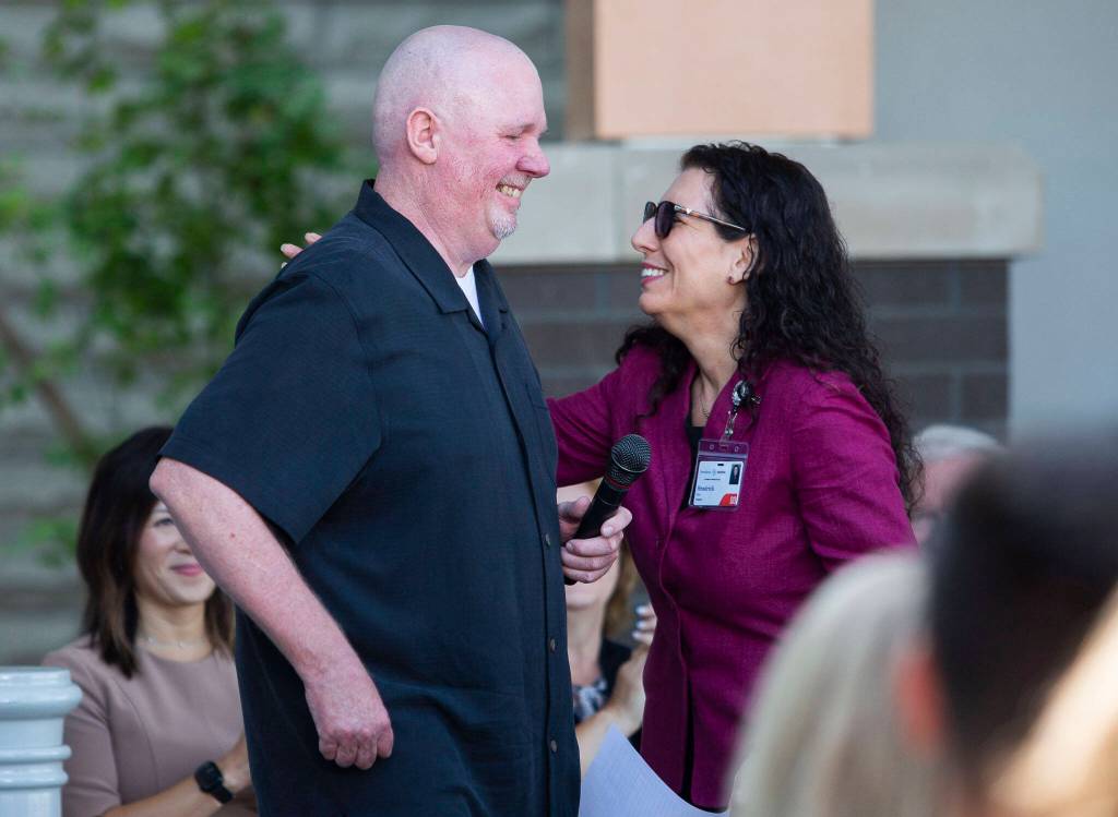 Thomas Cottrell, a former patient at Providence, walks up to the podium to give a testimonial about his care on Wednesday near Lynnwood. (Olivia Vanni / The Herald)