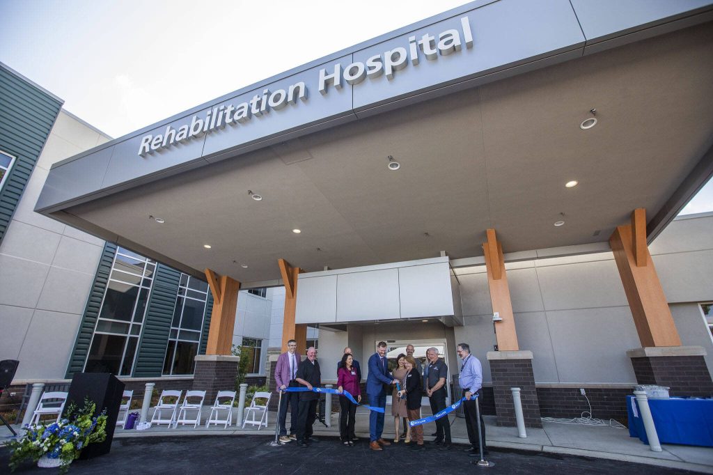 Community members and Providence Swedish employees cut the ribbon for the new Providence Swedish Rehabilitation Hospital on Wednesday near Lynnwood. (Olivia Vanni / The Herald)