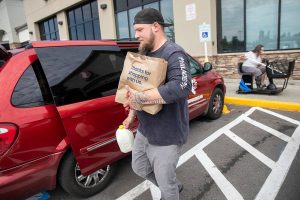 James Lee helps one of the Sky Valley Transportation Program Courage to Change riders load her groceries into the van on Monday, Aug. 19, 2024 in Monroe, Washington. (Olivia Vanni / The Herald)