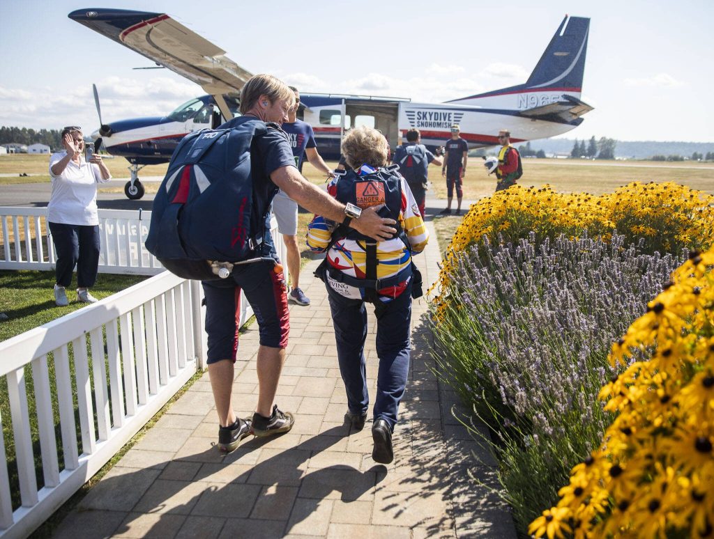 Kelly Craig places a hand on Kim Knors back as they make their way out to the plane on Wednesday, Aug. 14, 2024 in Snohomish, Washington. (Olivia Vanni / The Herald)
