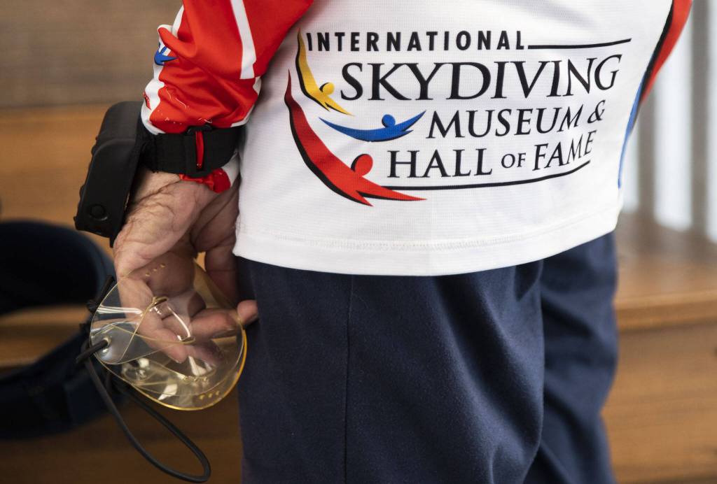Kim Knor wears her Skydiving Hall of Fame jump shirt and holds onto her goggles as she gears up before her skydive on Wednesday, Aug. 14, 2024 in Snohomish, Washington. (Olivia Vanni / The Herald)
