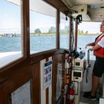 Capt. Kristi Schooley, of Argosy Cruises, navigates the Jetty Island ferry to the dock at while toting passengers to and fro in 2023, in Everett. (Ryan Berry / The Herald)