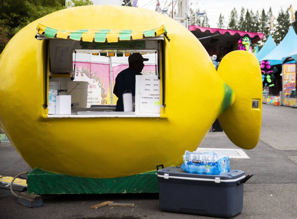 Workers set up vendor booths before the start of the Evergreen State Fair on Wednesday, Aug. 21, 2024, in Monroe, Washington. (Olivia Vanni / The Herald)