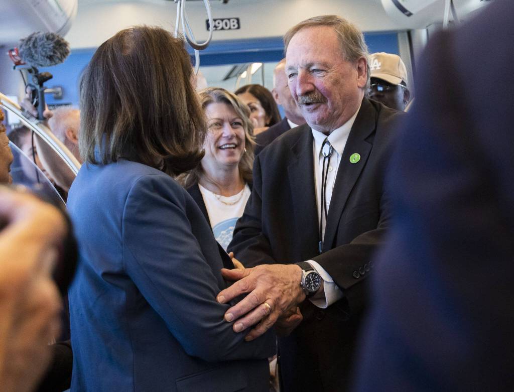Snohomish County Executive Dave Somers and Senator Maria Cantrell shake hands as they board the 12:30 pm train during the Lynnwood 1 Line extension opening celebrations on Friday, Aug. 30, 2024 in Lynnwood, Washington. (Olivia Vanni / The Herald)