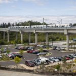 A Link train passes over a parking lot south of the Lynnwood City Center Station on Monday, Aug. 12, 2024 in Lynnwood, Washington. (Olivia Vanni / The Herald)