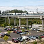 A Link train passes over a parking lot south of the Lynnwood City Center Station on Monday, Aug. 12, 2024 in Lynnwood, Washington. (Olivia Vanni / The Herald)