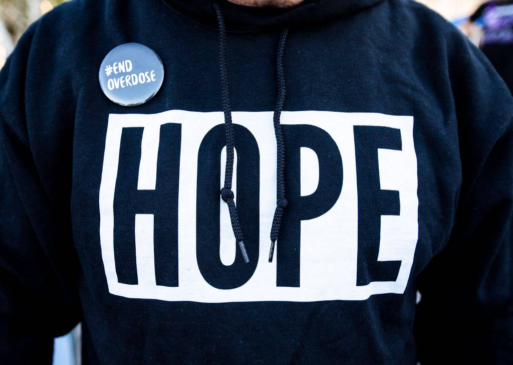 People wear HOPE sweatshirts and End Overdose pins during A Night to Remember, A Time to Act opioid awareness event at the Snohomish County Campus on Thursday in Everett.