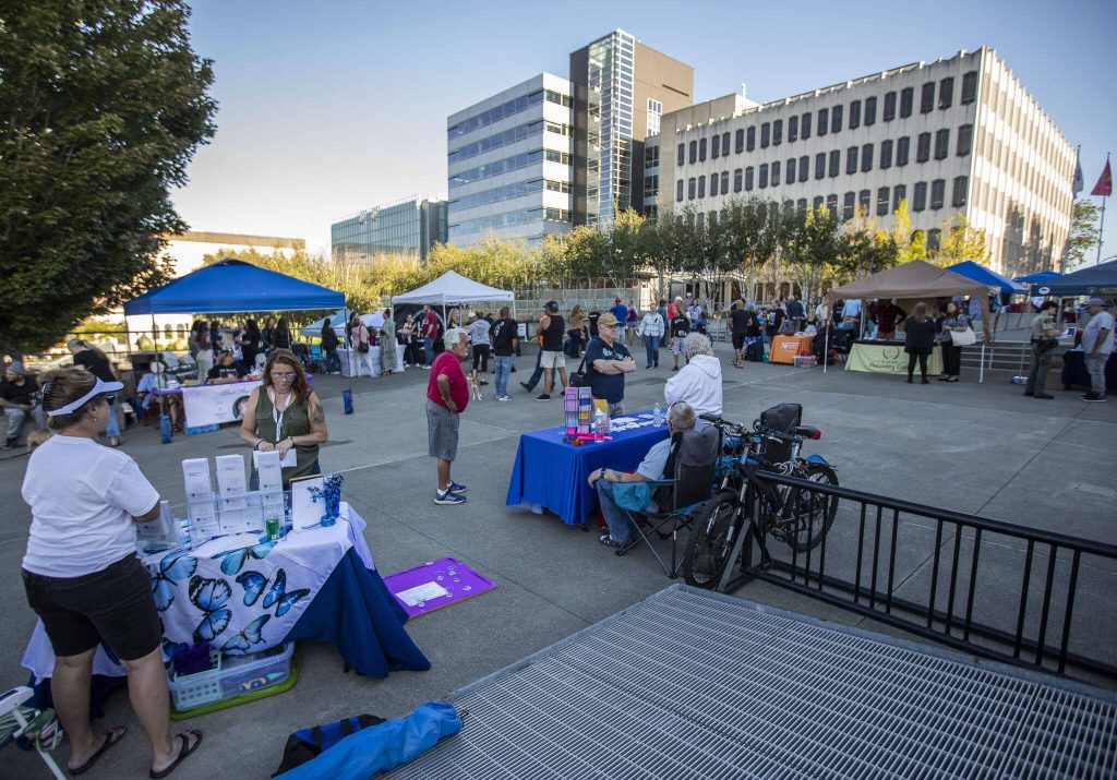 Hundreds wander through a resource fair set up during A Night to Remember, A Time to Act opioid awareness event at the Snohomish County Campus on Thursday in Everett.