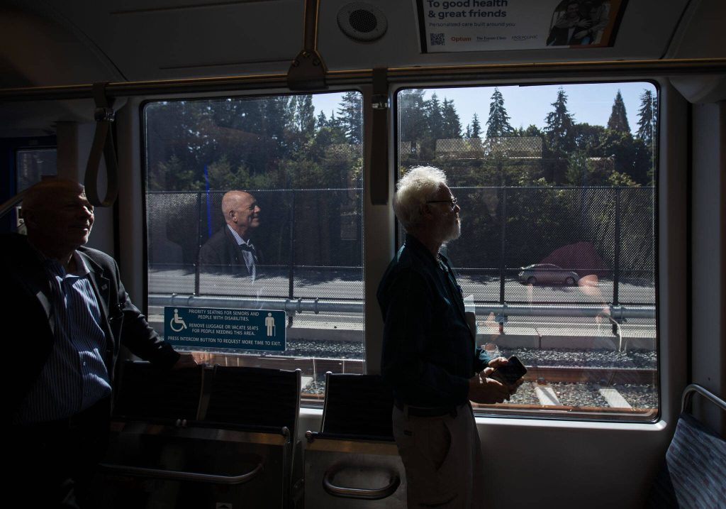 People are illuminated by sunlight as they ride the Link light rail on Wednesday, Aug. 28, 2024 in Mountlake Terrace, Washington. (Olivia Vanni / The Herald)