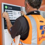 A Sound Transit employee places a fare and scheduling sheet at the Mountlake Terrace station on Wednesday, Aug. 28, 2024 in Mountlake Terrace, Washington. (Olivia Vanni / The Herald)