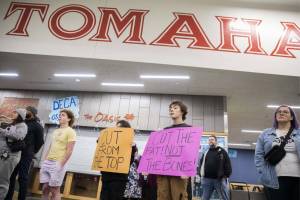 Pierce Butcher, 15, right, a sophomore at Marysville Getchell, holds a sign in silent protest at the Marysville School District budget presentation on Nov. 28, 2023 in Marysville, Washington. (Olivia Vanni / The Herald)