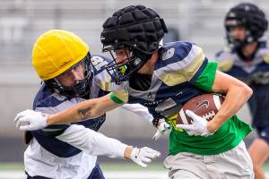 Arlington’s Kade Hunter runs the ball during practice on Monday, Sept. 2, 2024 in Arlington, Washington. (Olivia Vanni / The Herald)